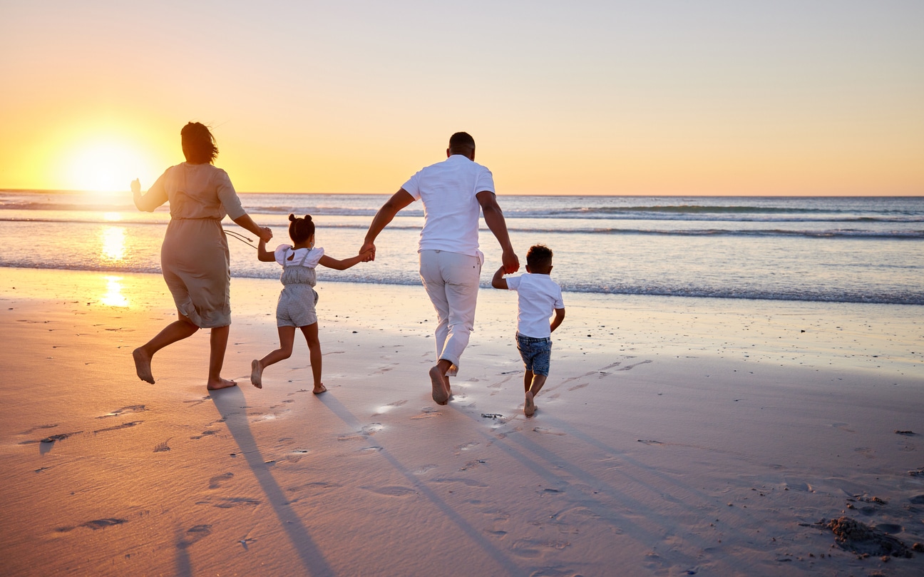 famille joyeuse sur la plage au coucher du soleil